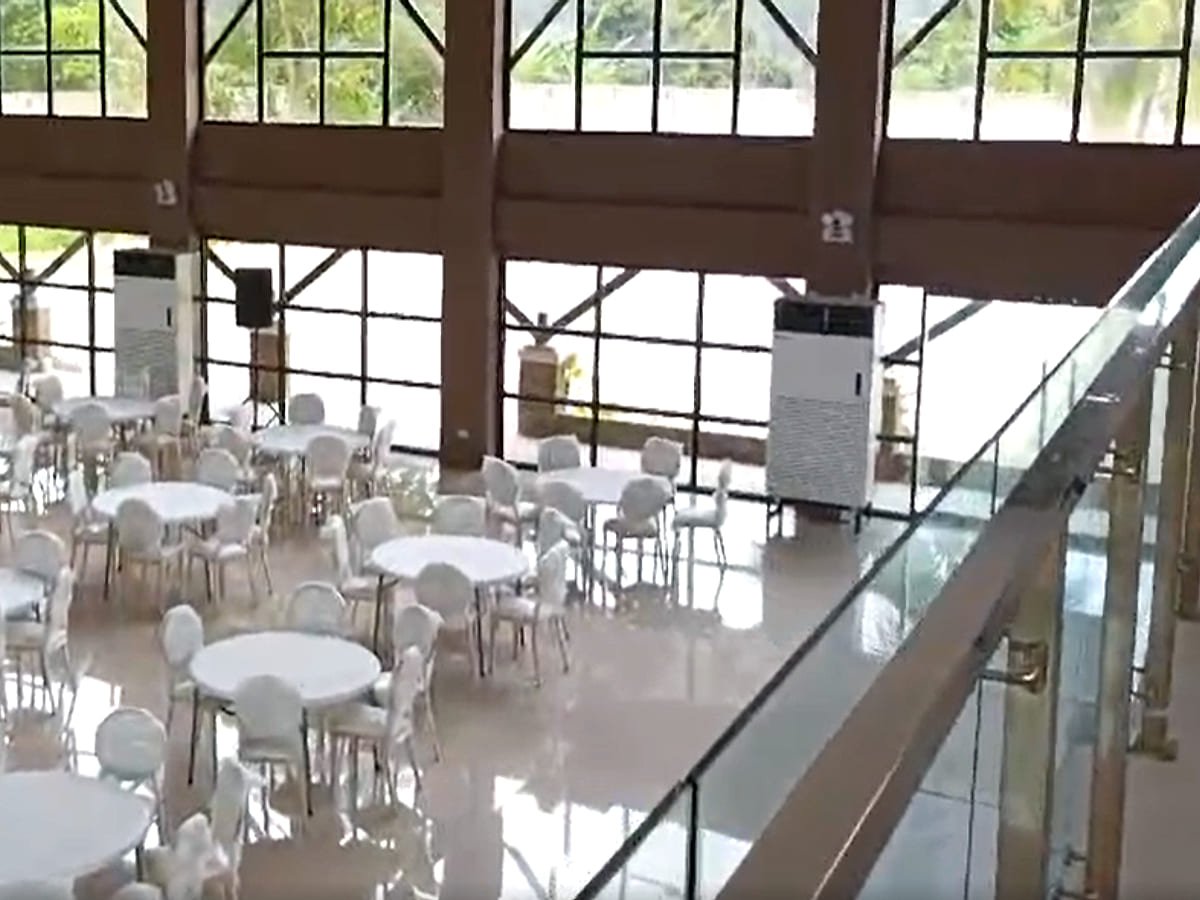 Floor-standing air conditioning units cooling a function hall set with tables and chairs